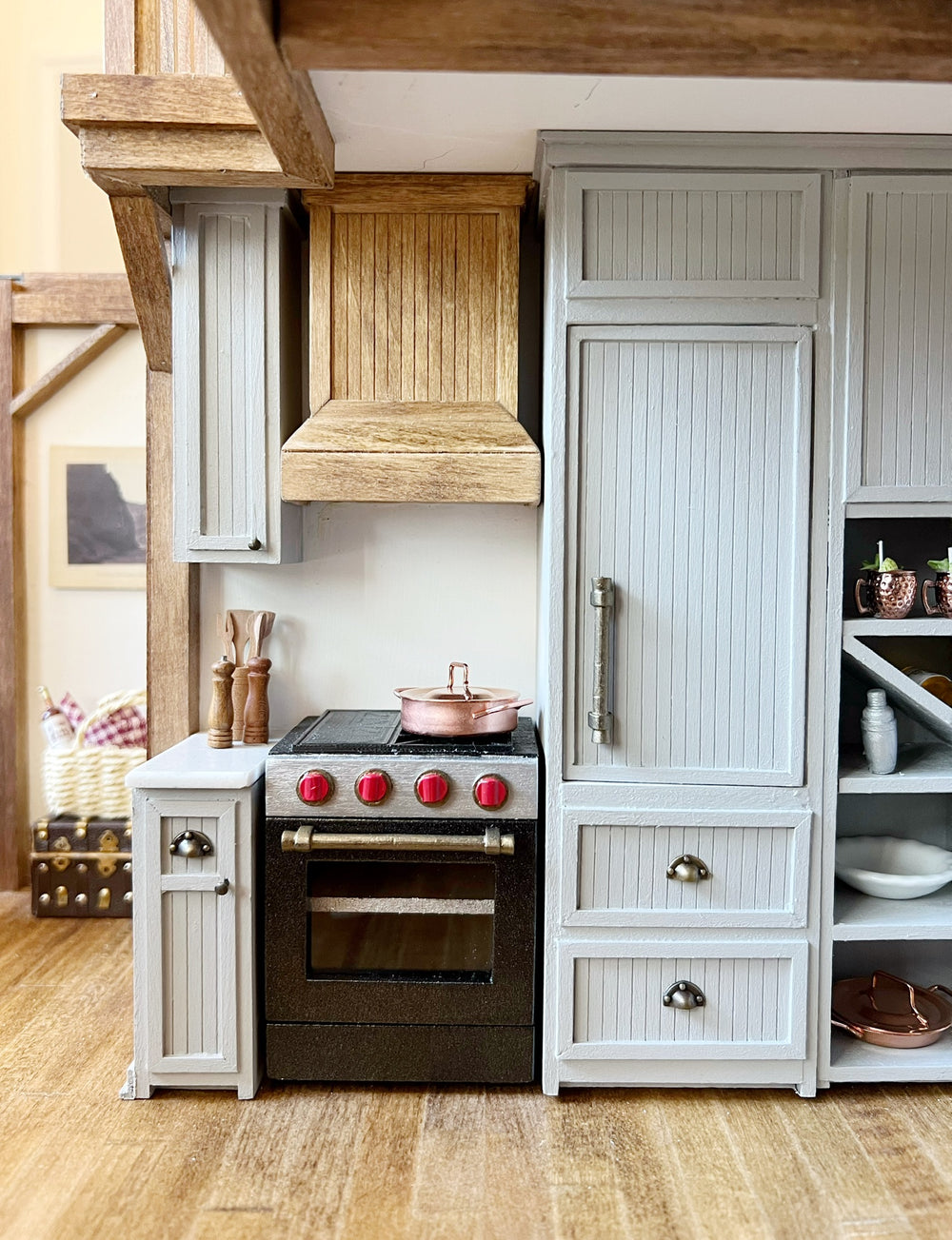 A miniature kitchen with a copper pot on a black range